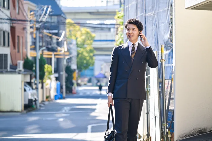 街中で電話をしながら物件情報を集める社員